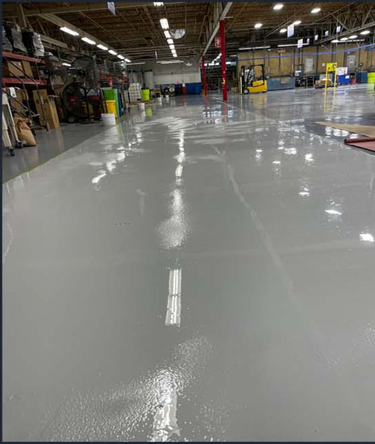 Smooth gray coated concrete floor in a warehouse aisle