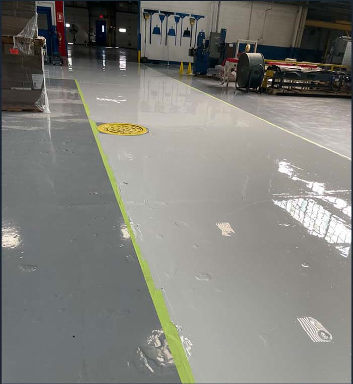 Gray coated floor with a green aisle marking